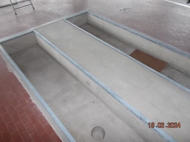 Dreiteilige Inspektionsgrube aus Beton in einer Garage.