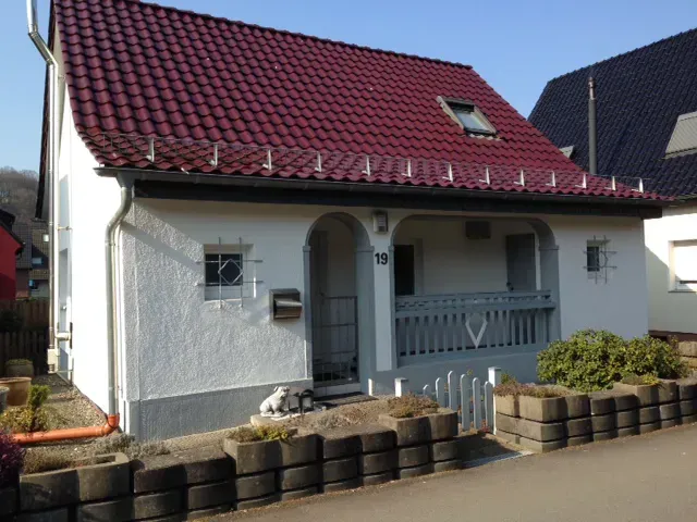 Ein weißes Haus mit einem roten Ziegeldach