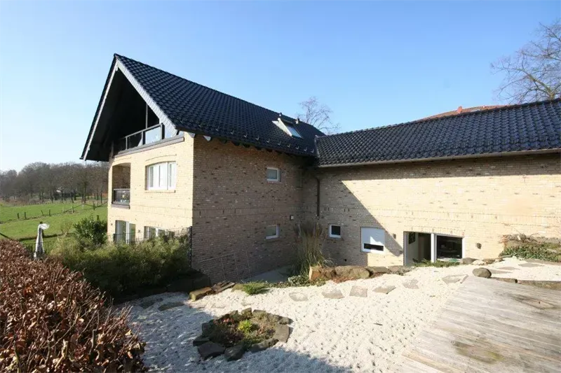 Ein großes Backsteinhaus mit einem schwarzen Dach