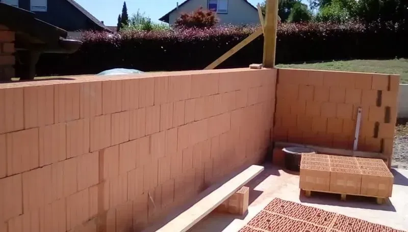 An einem sonnigen Tag wird eine Ziegelmauer gebaut