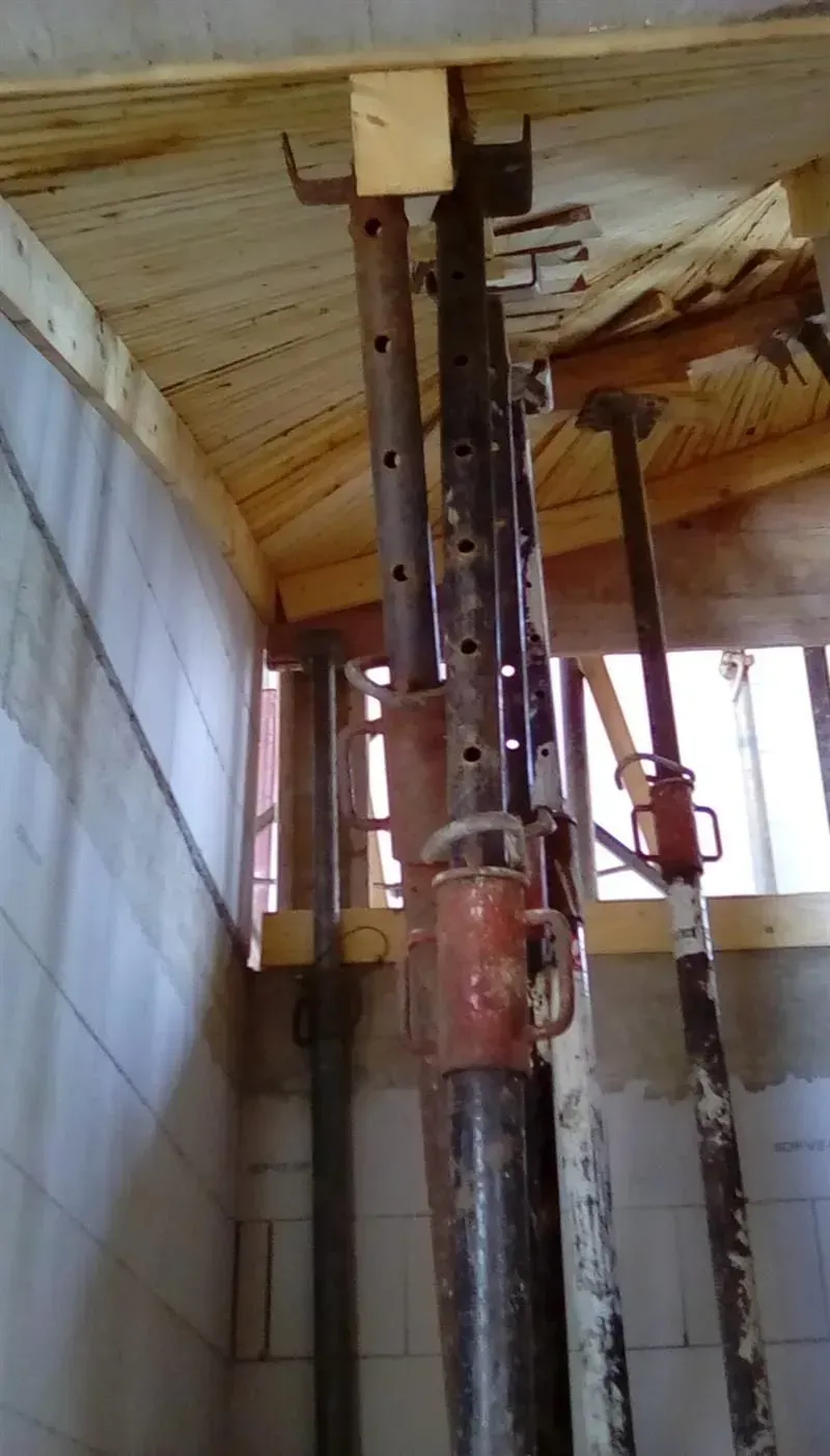 Von der Decke eines Gebäudes hängen mehrere Metallstangen.