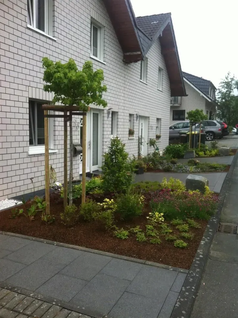 Ein weißes Backsteinhaus mit einem Garten davor