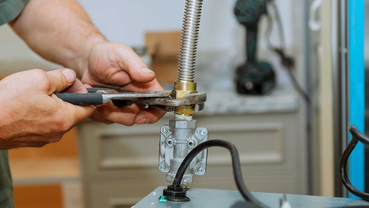 Persona que utiliza alicates para apretar un accesorio de plomería.