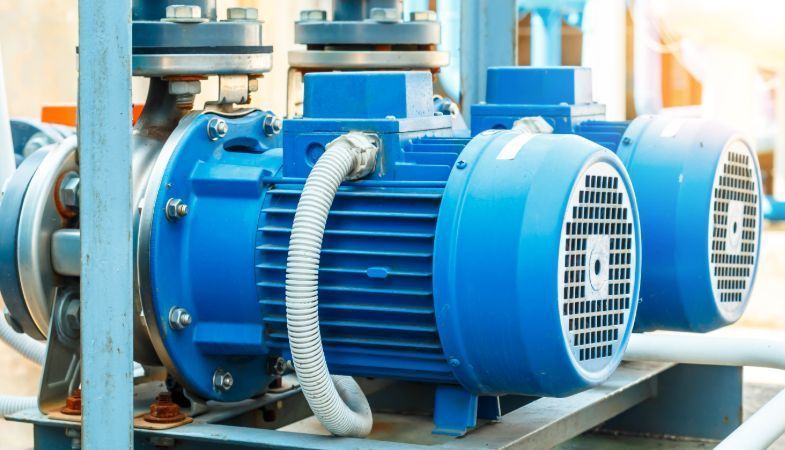 Bombas industriales azules con conducto eléctrico, parte de un sistema.