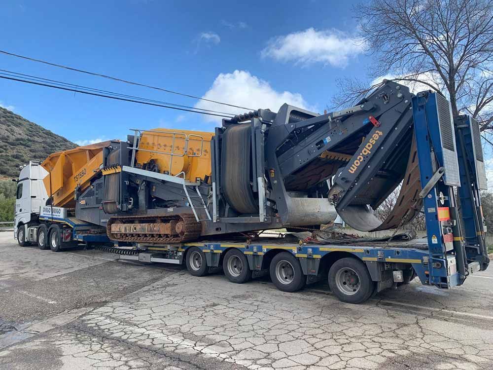 Un camión transporta una máquina grande en un remolque.