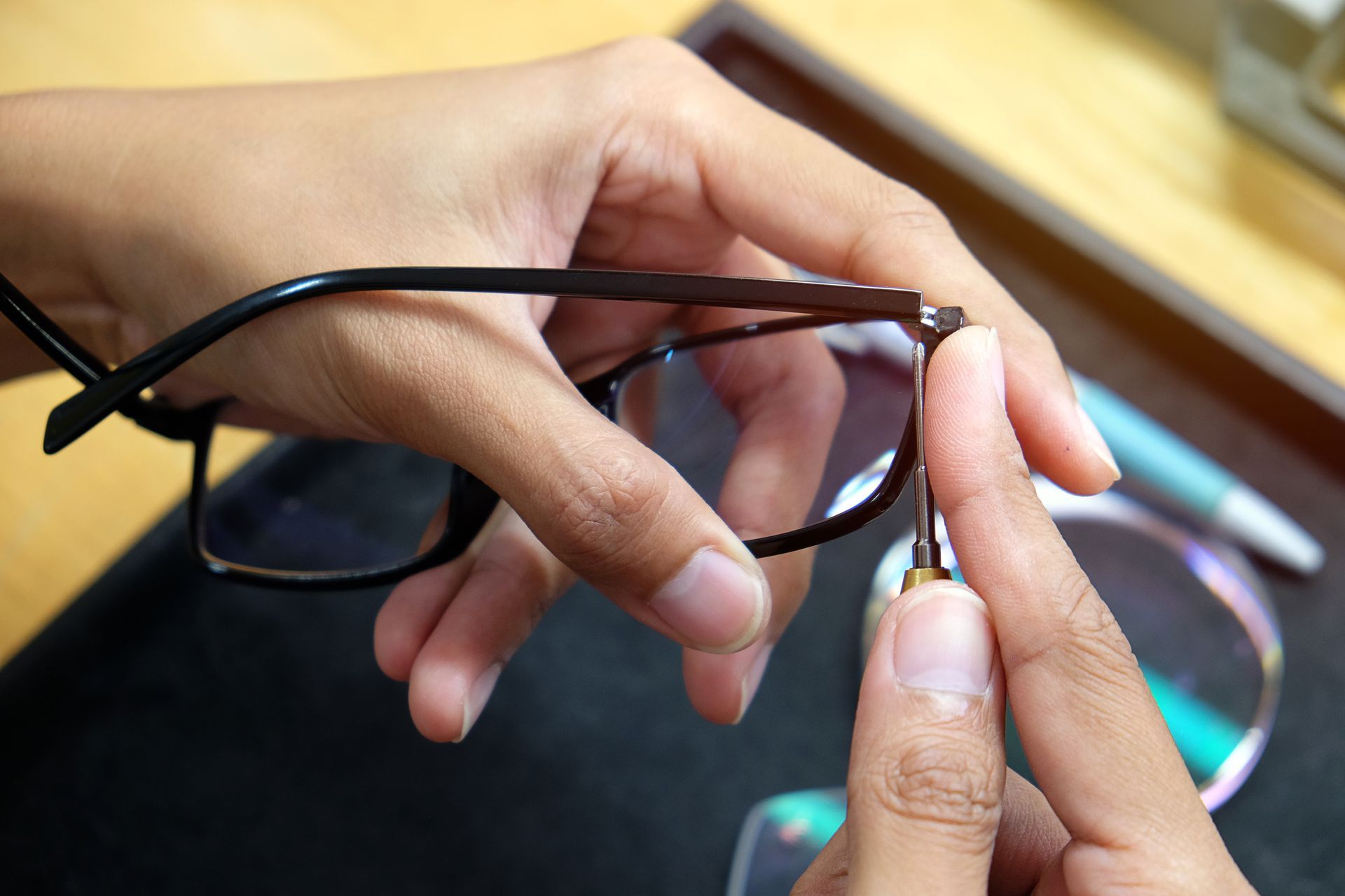 Réparation d'une paire de lunettes par un opticien