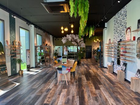 Boutique de lunettes avec des étagères, une table et des chaises.