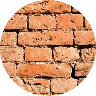 Primer plano de una pared de ladrillos rojos desgastados.