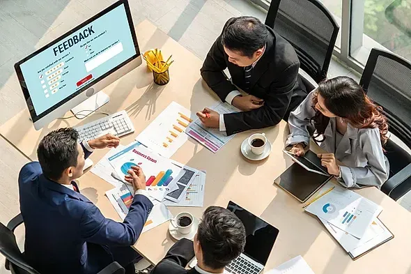 Equipo de negocios revisando datos y comentarios durante una reunión en una oficina.