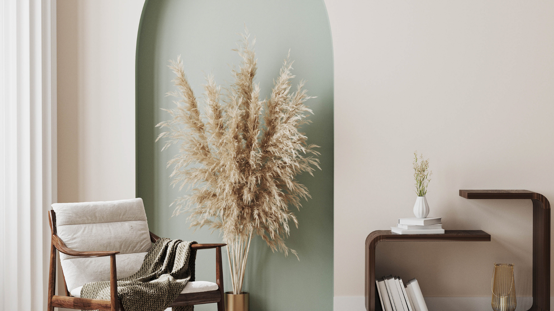 Espace de vie aux tons neutres avec fauteuil, herbes de la pampa, étagères intégrées et arche peinte en vert sauge.