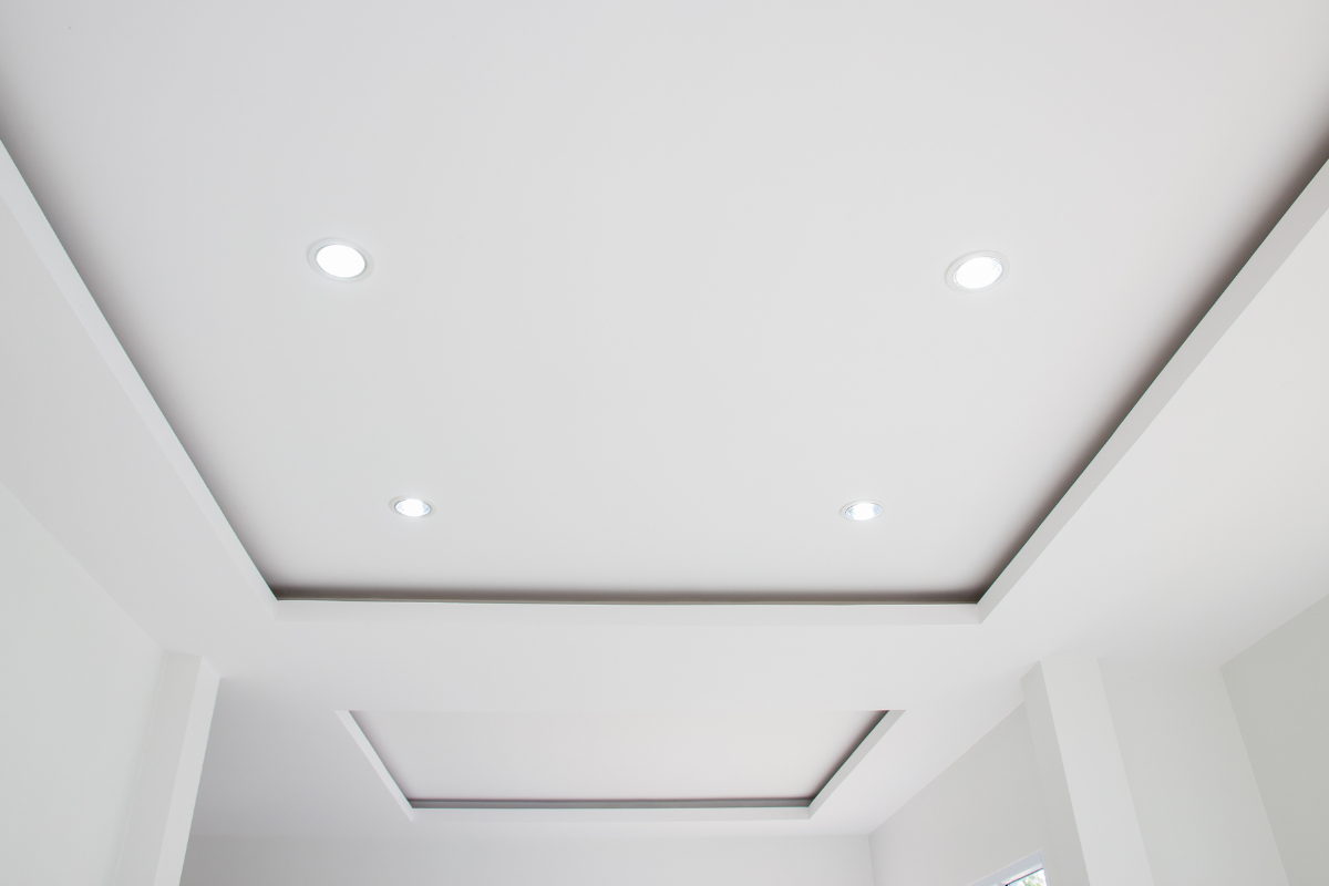 Plafond blanc avec éclairage encastré et motif rectangulaire encastré.