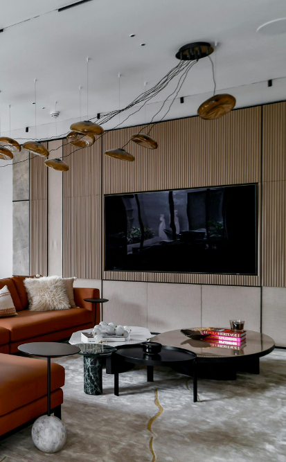 Salon moderne avec une grande télévision, un canapé d'angle marron et un éclairage élégant.