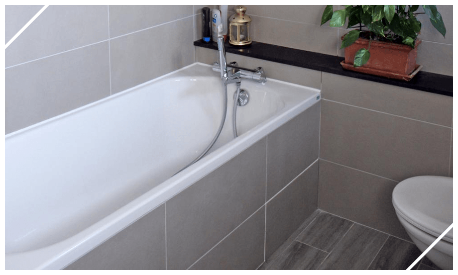 Baignoire avec tablier carrelé et toilettes