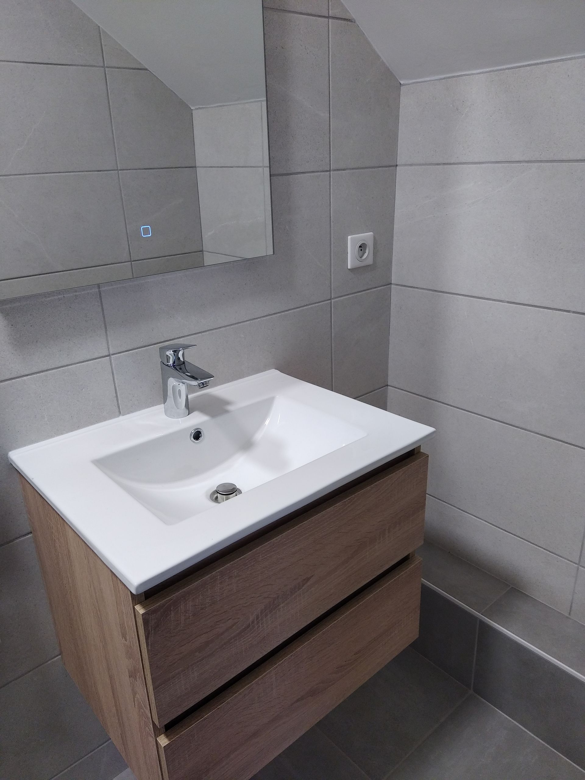 Meuble de salle de bains avec miroir, faïence et carrelage gris