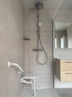Douche italienne avec mise en place d'une chaise pour personne dans le besoin