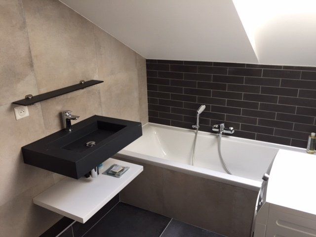 Salle de bains sous pente avec vasque suspendue et baignoire