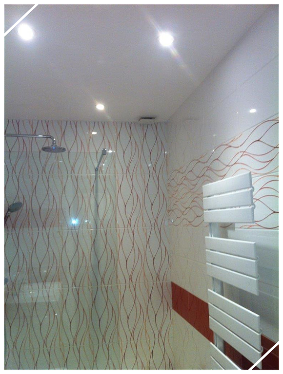 Douche, paroi vitrée et faïence avec motifs vagues