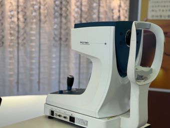 Appareil d'examen ophtalmologique, blanc avec des touches turquoise.