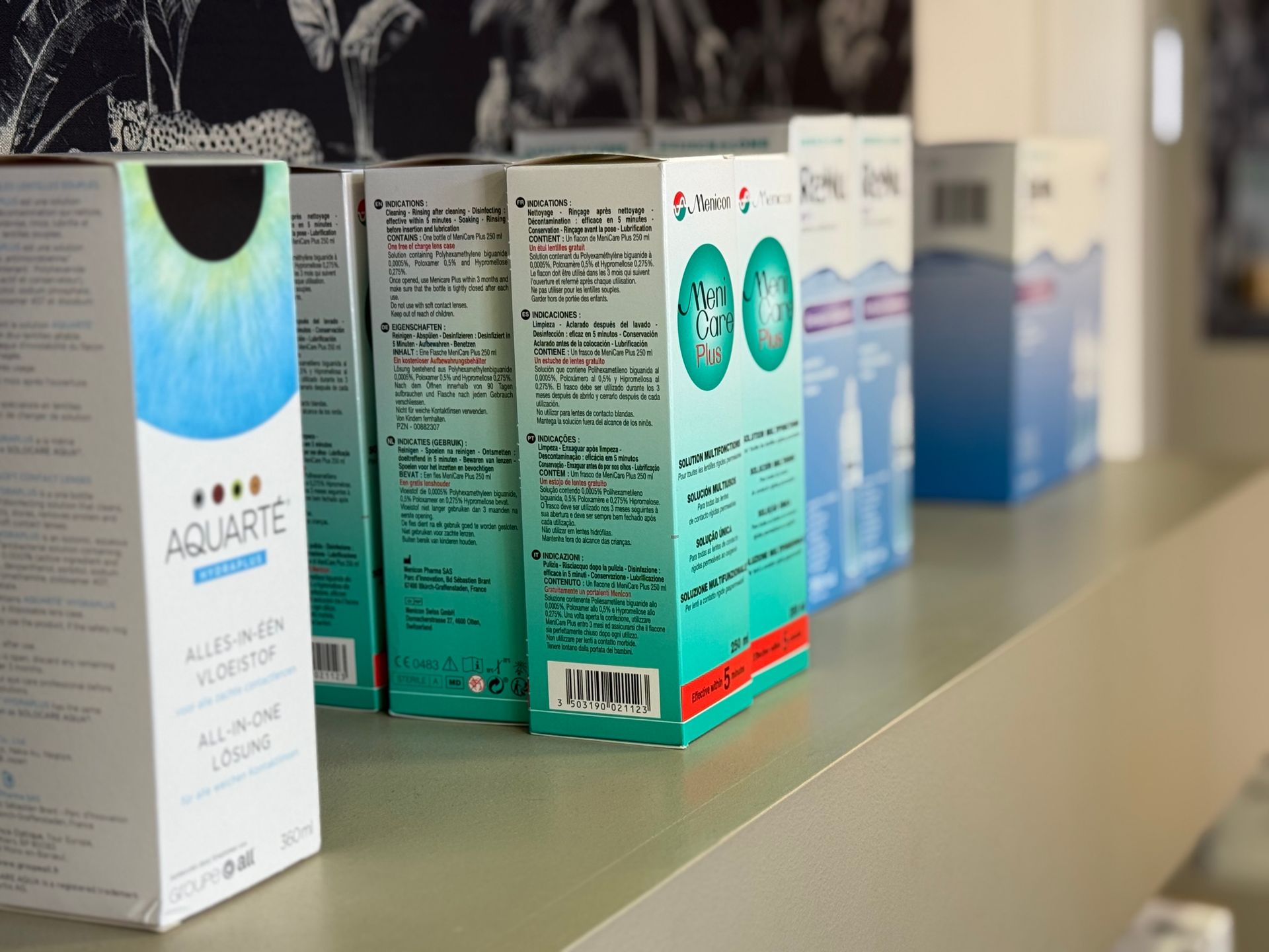 Des boîtes de lentilles de contact sont rangées sur une étagère.