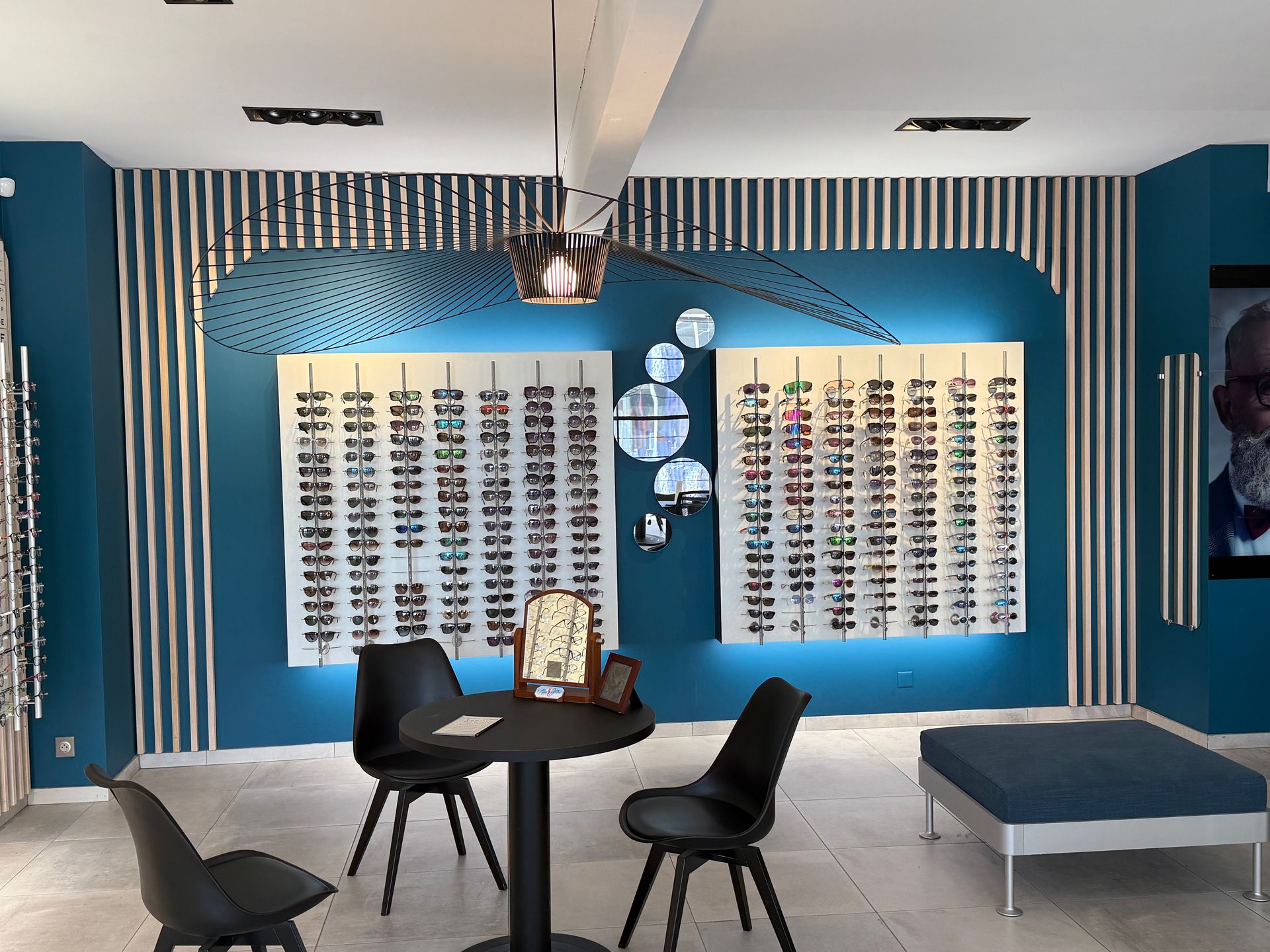 Intérieur d'un magasin d'optique avec des présentoirs à lunettes.