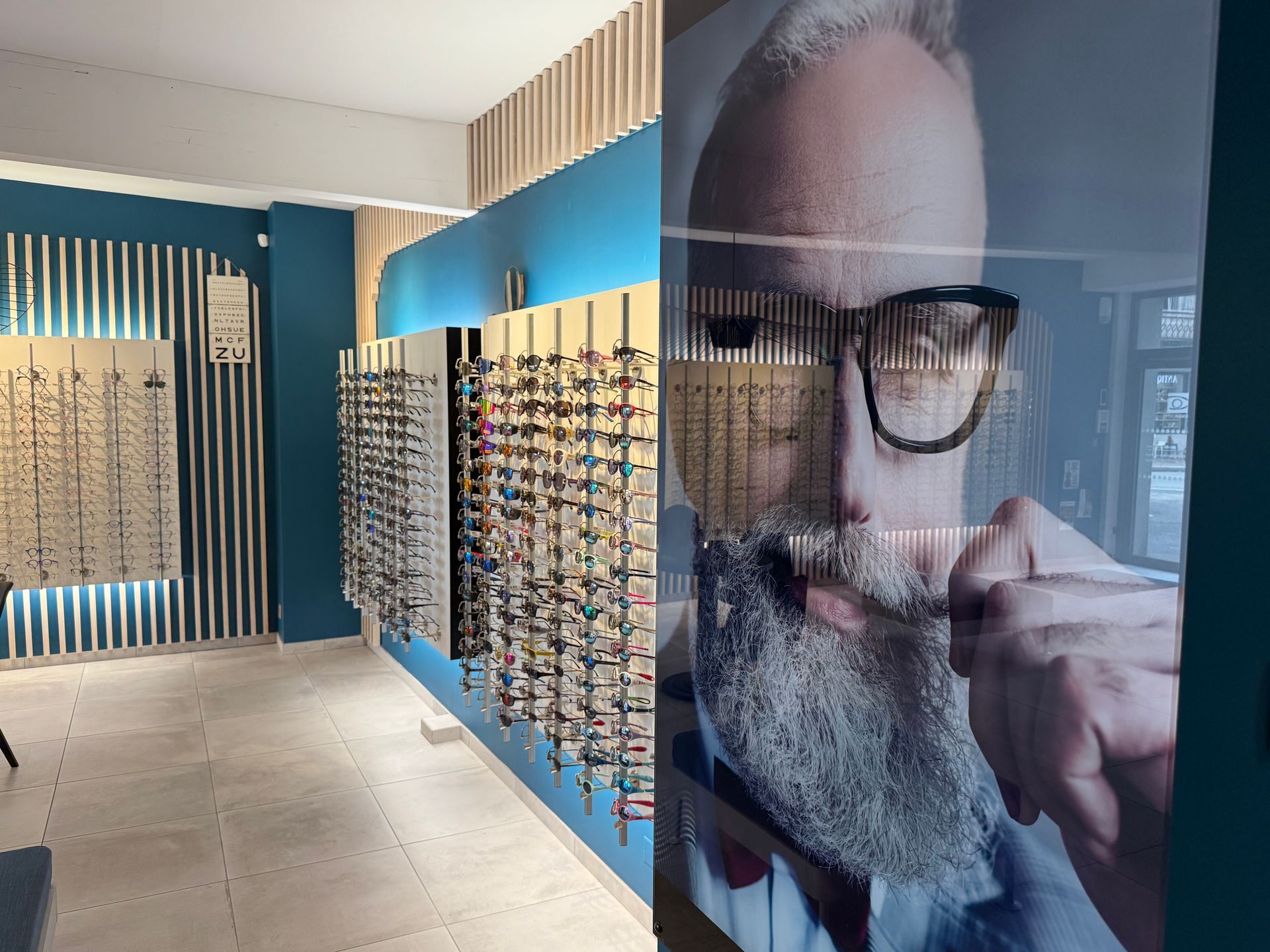Intérieur d'un magasin d'optique avec présentoir de lunettes.
