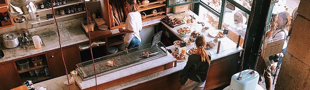 Vue aérienne d'un café avec des personnes, un comptoir et divers objets.