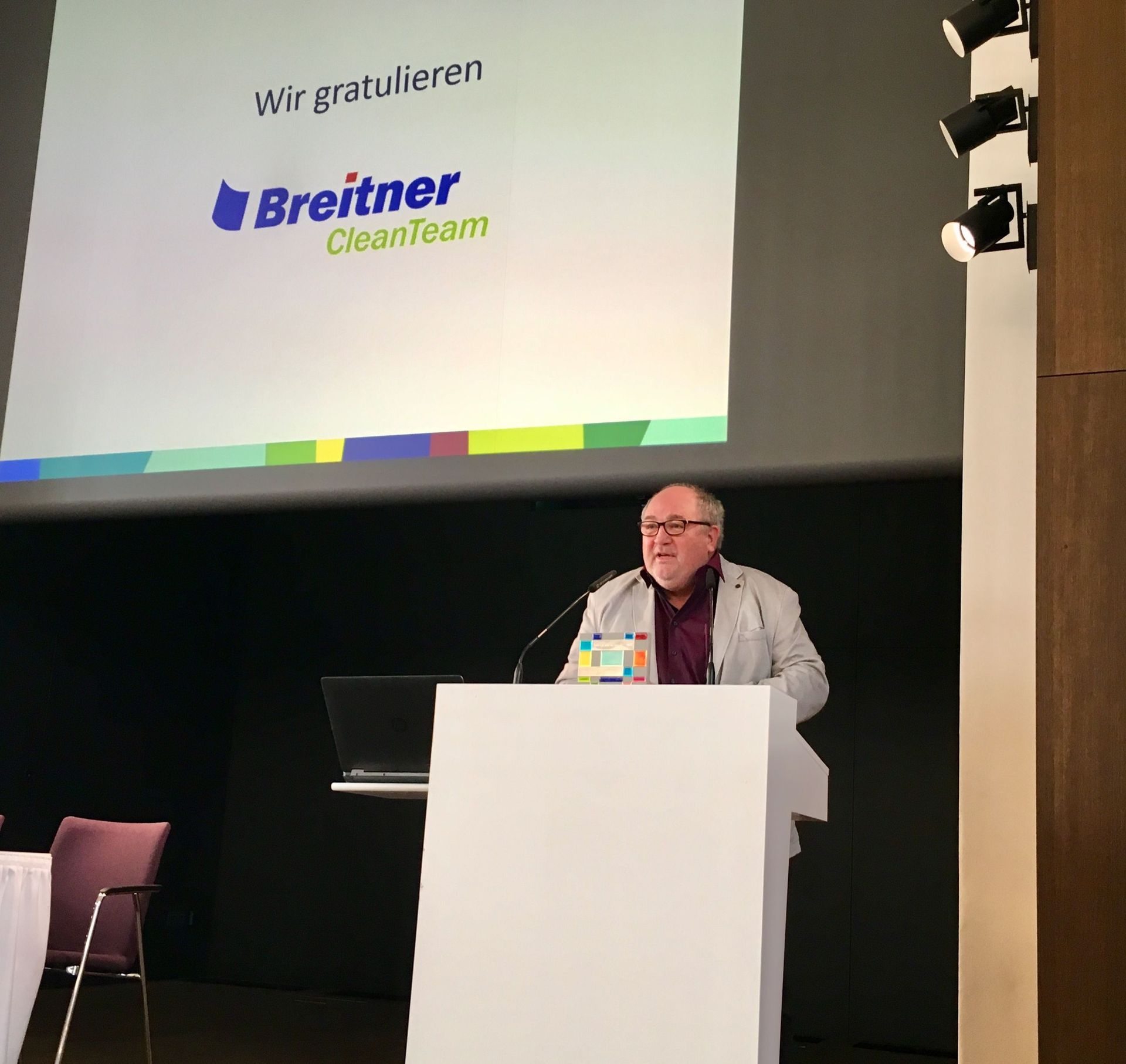Ein Mann steht auf einem Podium vor einem Breitner-Logo