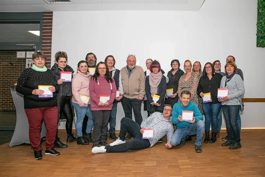 Eine Gruppe von Menschen posiert in einem Raum für ein Foto.