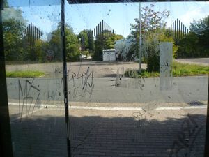Ein Fenster mit Graffiti darauf und eine Straße im Hintergrund.