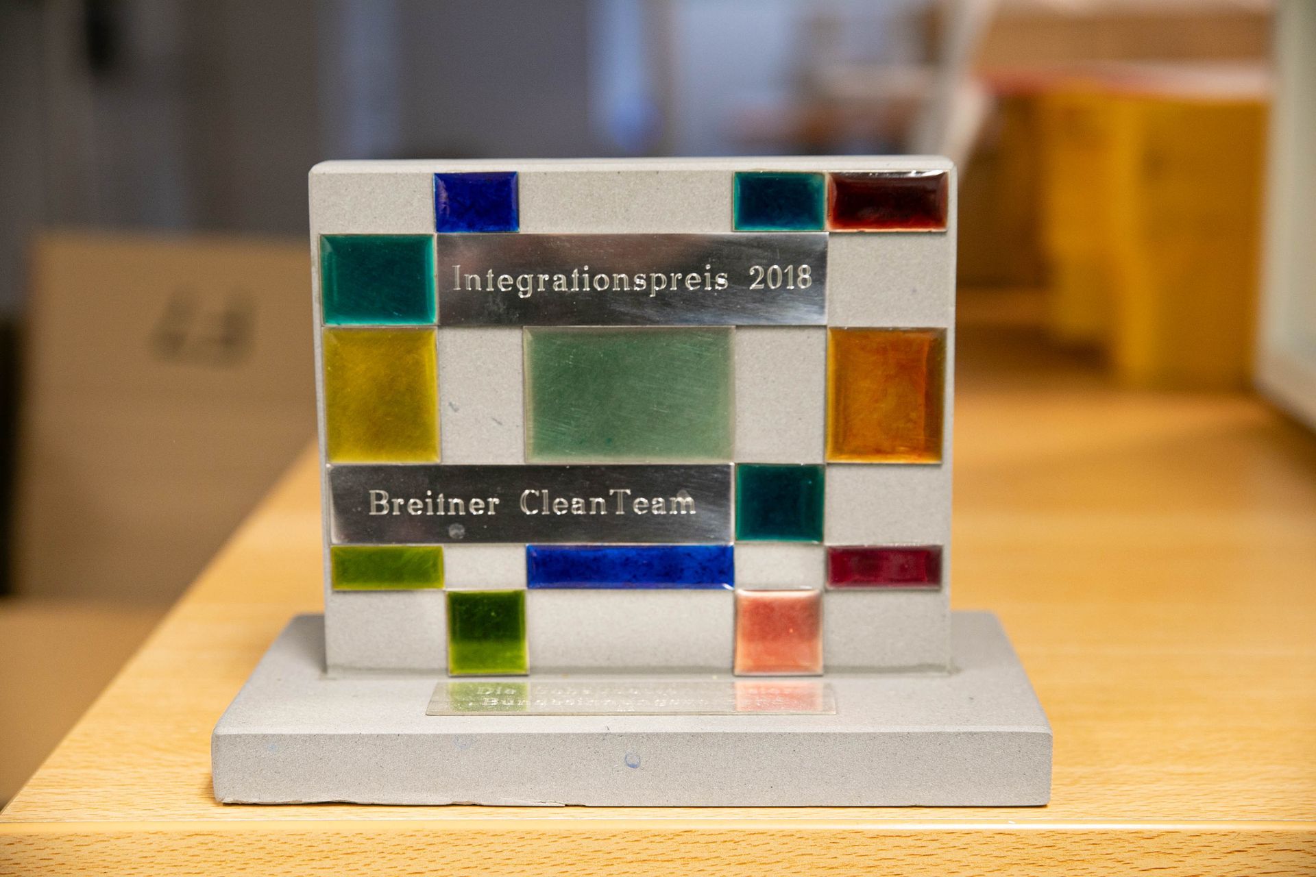 Auf einem Holztisch liegt eine Buntglastafel.