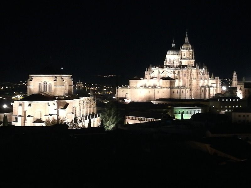 Un gran edificio está iluminado por la noche en una ciudad.
