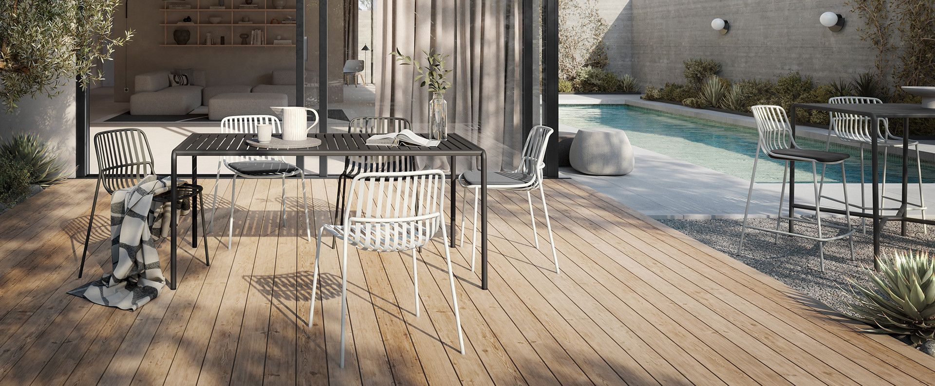 Bureau moderne avec un long bureau, une chaise rouge, un ordinateur portable, des livres et une grande fenêtre donnant sur la ville.