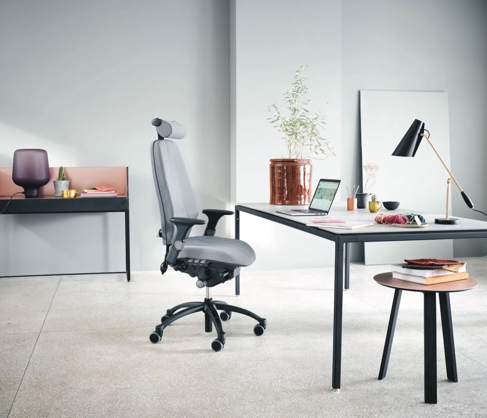 Bureau moderne avec bureaux, ordinateurs et éclairage au plafond. Parquet clair, murs blancs et cloisons vitrées.