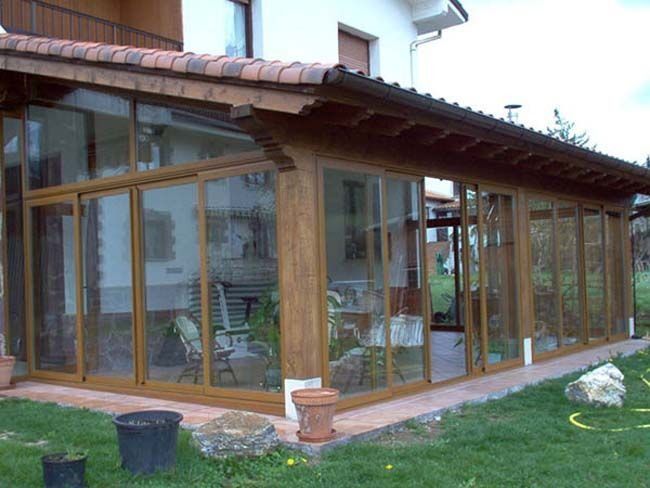 Una casa con muchas ventanas a los lados.