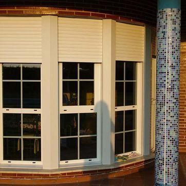 Un edificio de ladrillo con una gran ventana con contraventanas.