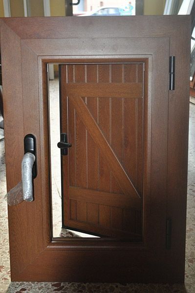 Una puerta de madera con manija de metal está sobre un piso de baldosas.