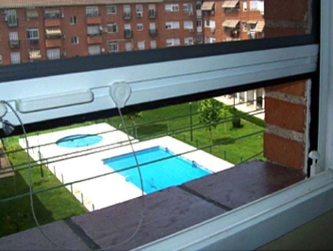 Una vista de una piscina a través de una ventana.