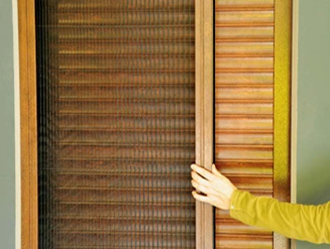 Una persona está abriendo una puerta de madera con una mampara.