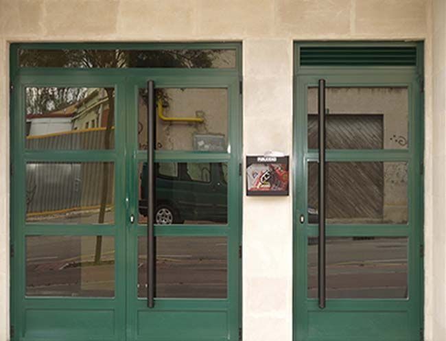 Una puerta verde con un coche aparcado delante de ella.