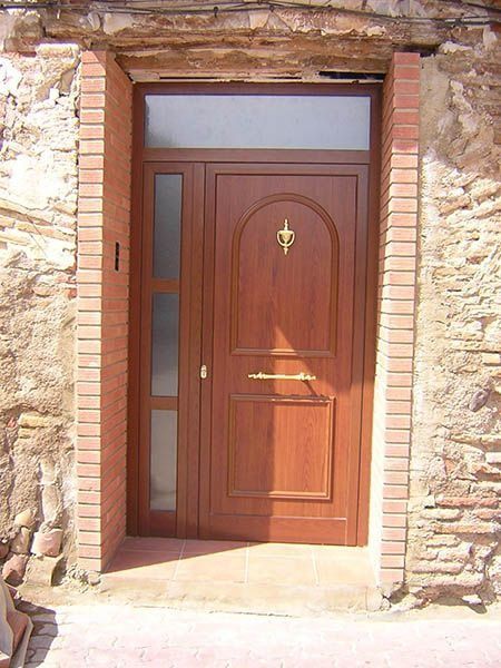 Una puerta de madera con una pared de ladrillos detrás