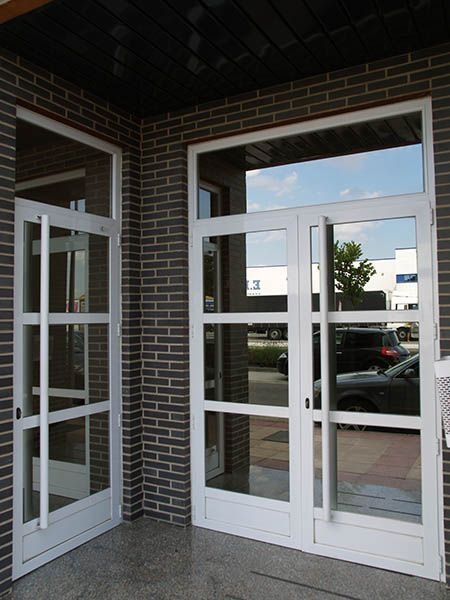 Un edificio de ladrillo con puertas y ventanas blancas