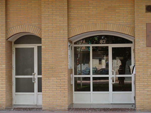 Un edificio de ladrillo con puertas blancas y un cartel que dice 92