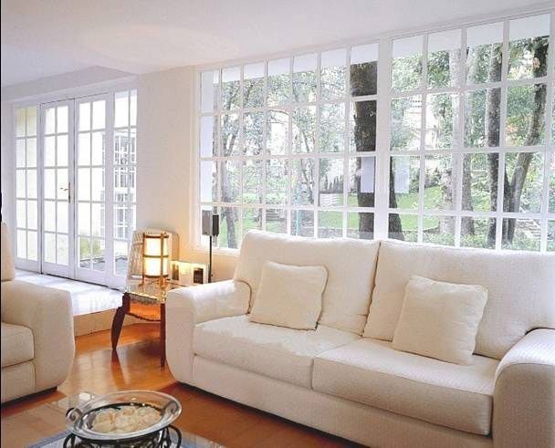 Una sala de estar con un sofá blanco y puertas corredizas de vidrio.