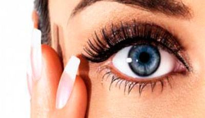 Un primer plano del ojo azul de una mujer con pestañas largas.