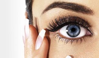 Un primer plano del ojo azul de una mujer con pestañas largas.