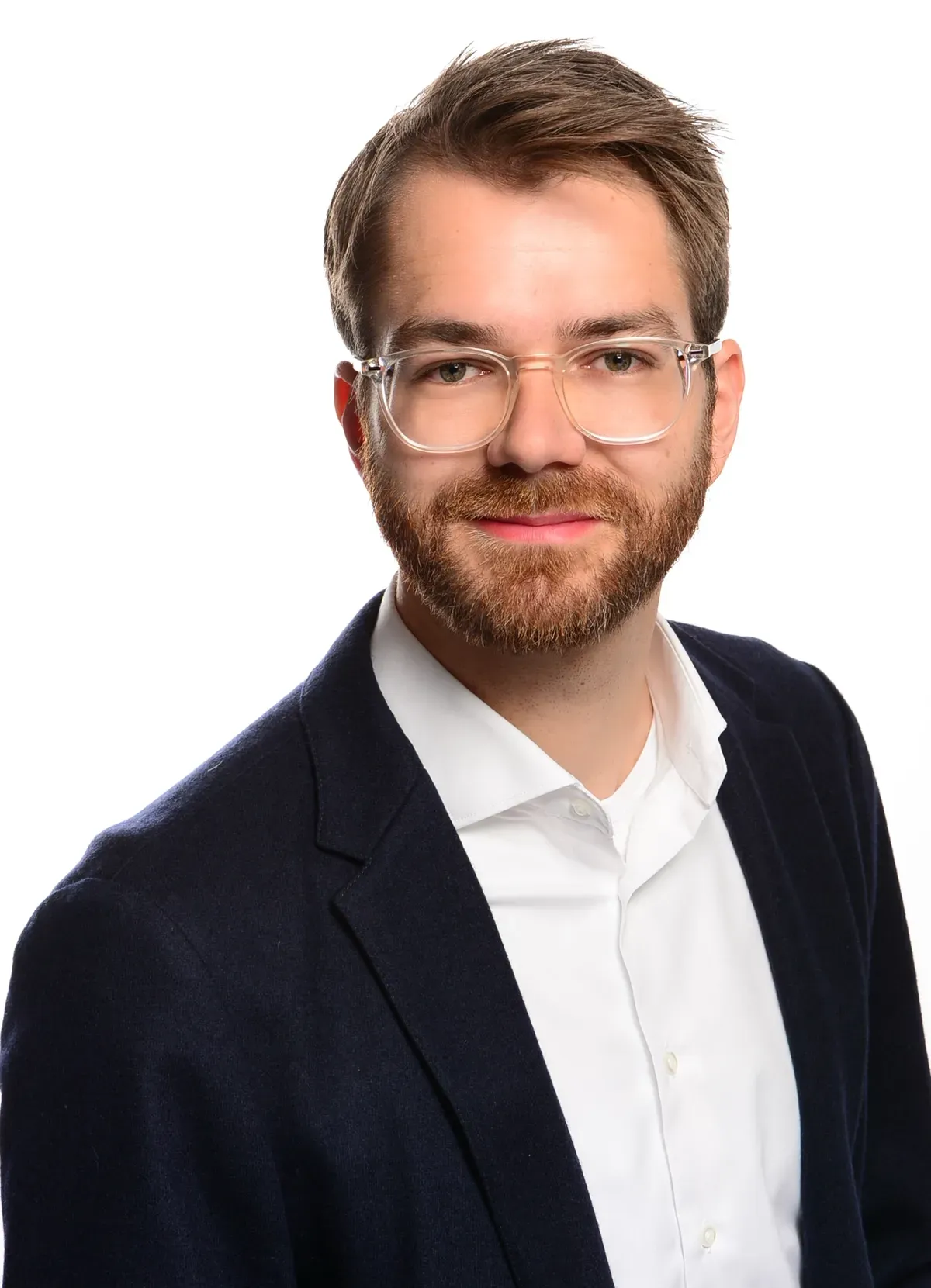 Ein Mann mit Bart und Brille trägt einen Anzug und ein weißes Hemd.