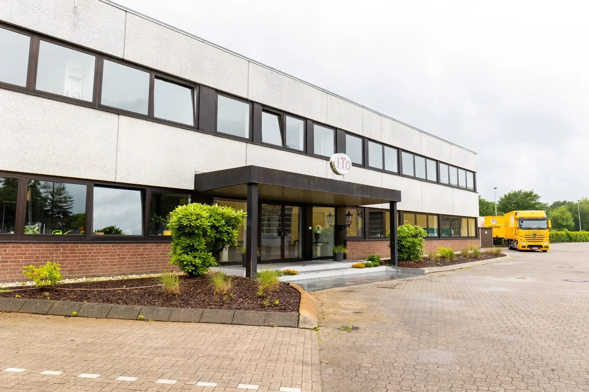 Ein großes Gebäude mit einem davor geparkten gelben Lastwagen