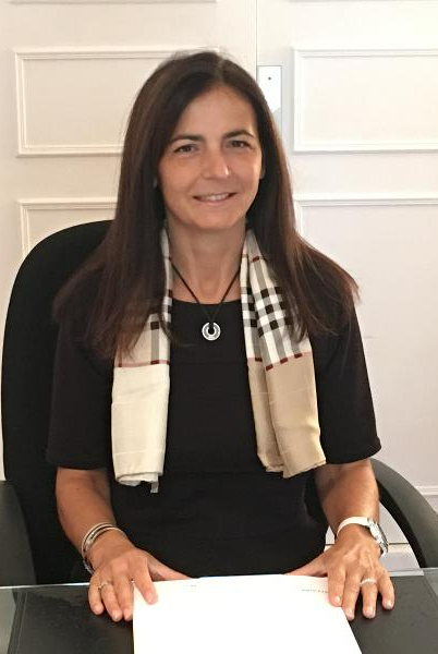 Femme avec un foulard noir, assise à un bureau.