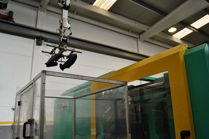 Una máquina verde y amarilla está siendo levantada por una grúa.