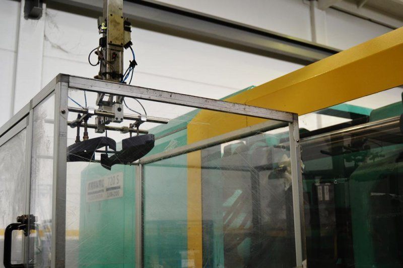 Una máquina verde y amarilla con un brazo robótico encima.